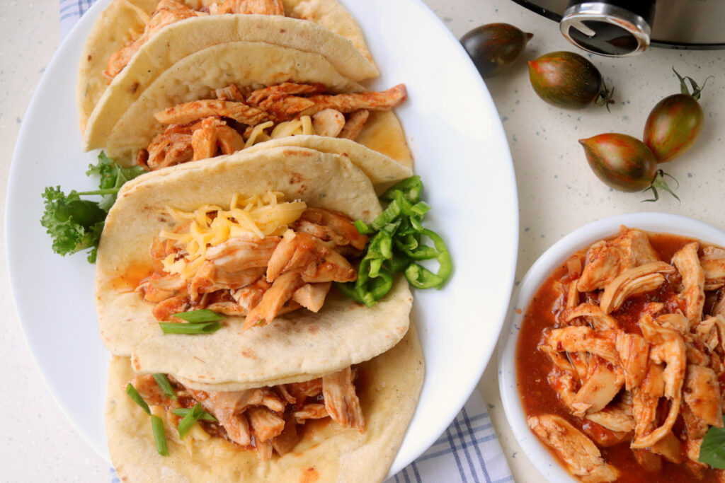bbq pulled chicken tacos on a plate.