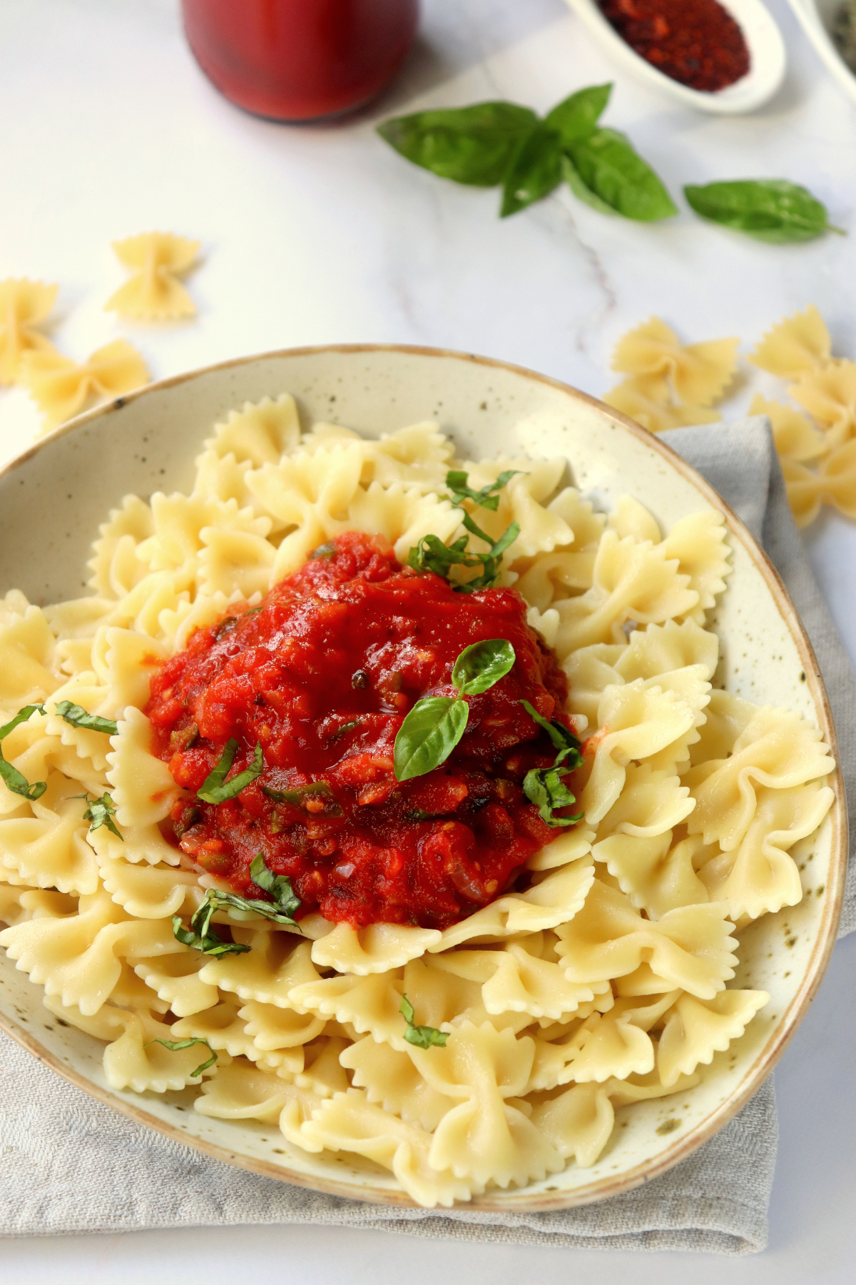 plate of pasta with marinara sauce on top.