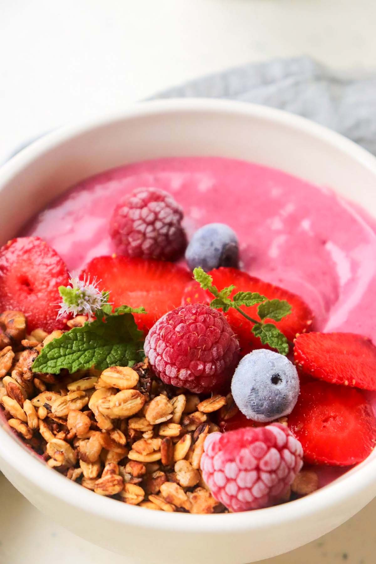 Smoothie bowl topped with fruit and granola.