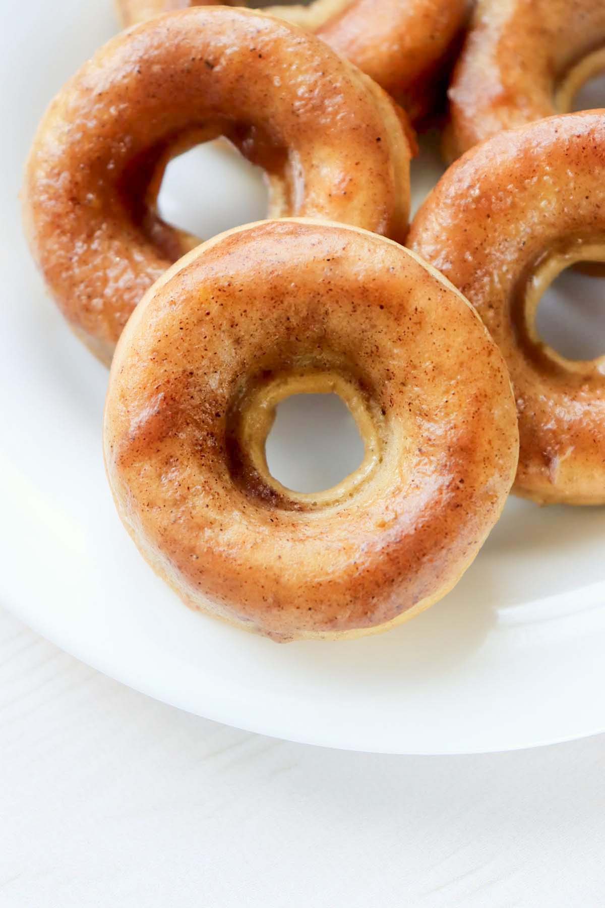 Glazed donut on a white plate.