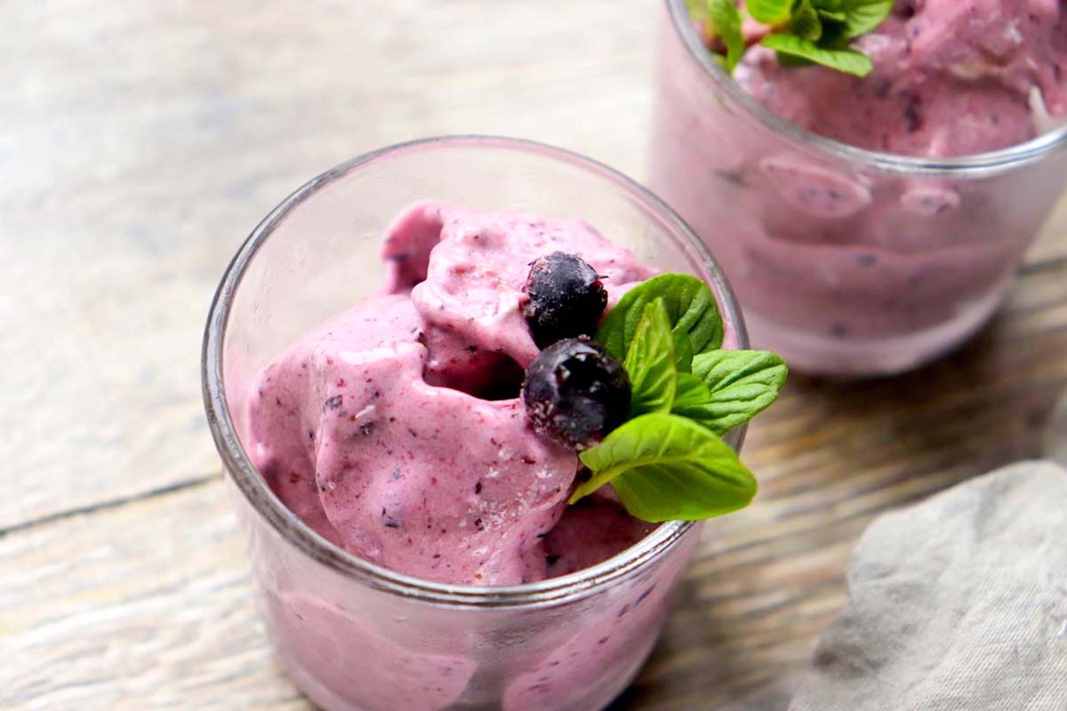 Nice cream topped with frozen blueberries.