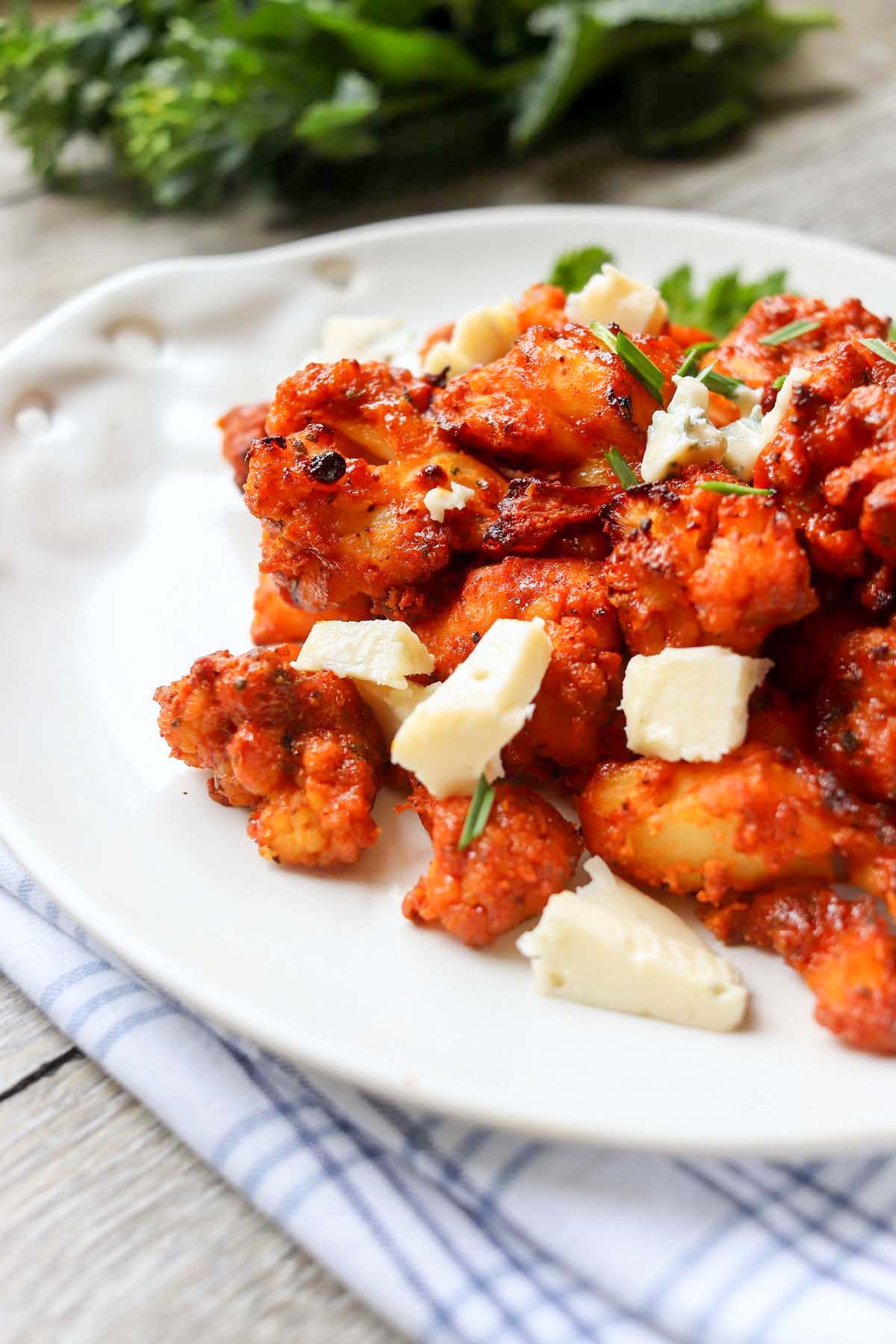 buffalo cauliflower and cheese cubes on a plate.
