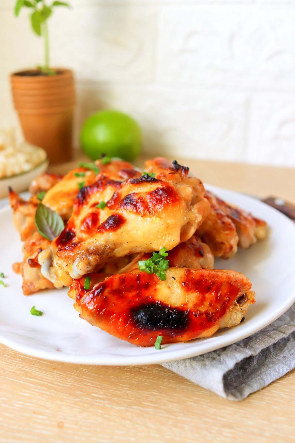 Wings on a plate set on a wood table.