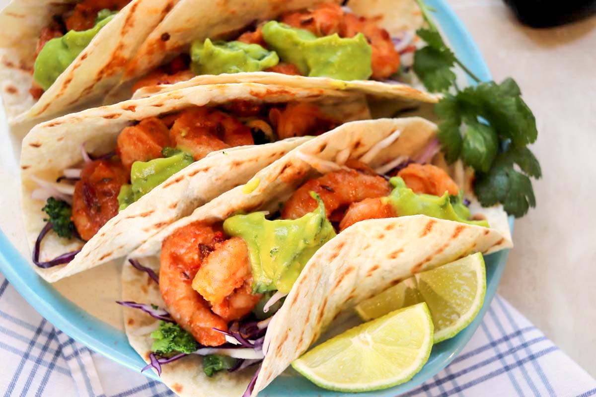 Shrimp tacos on a blue plate.