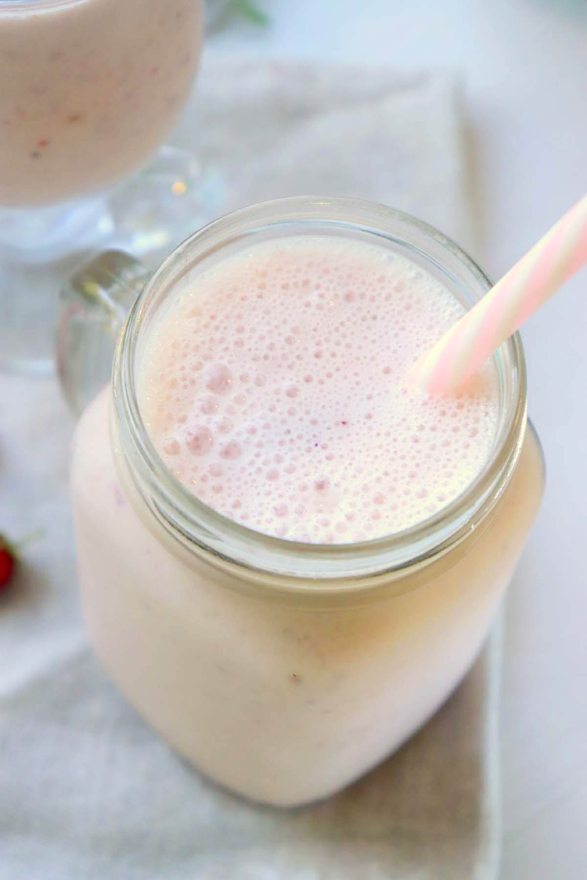 Smoothie in a jar with a pink straw.
