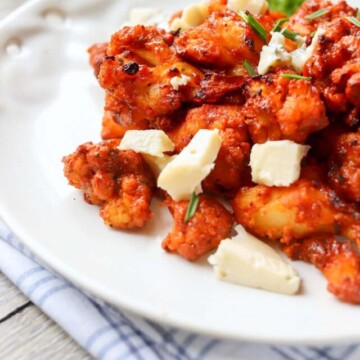 buffalo cauliflower and cheese cubes on a plate.