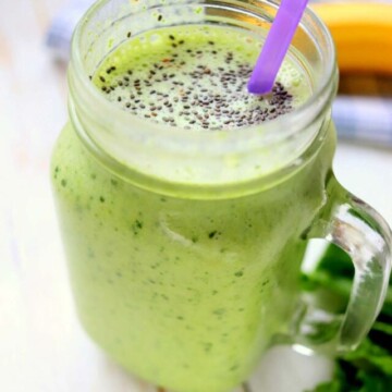 green protein smoothie in a jar with a straw.