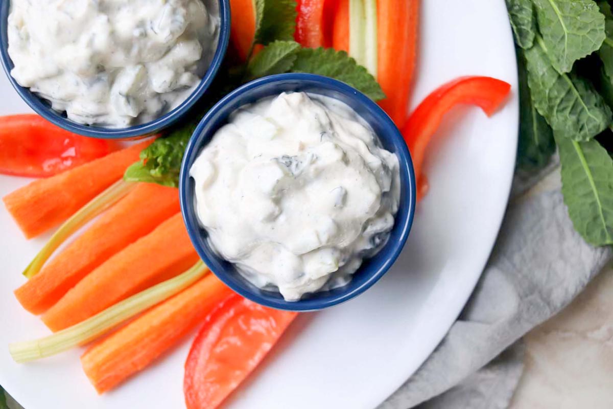 Dip in a blue bowl set on a white plate.