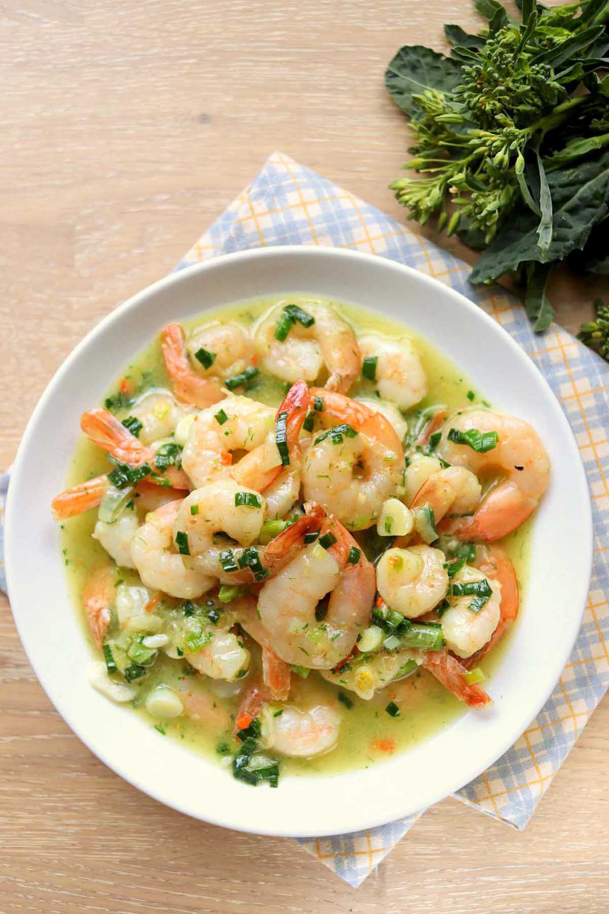 Shrimp scampi on a plate set on a kitchen towel.