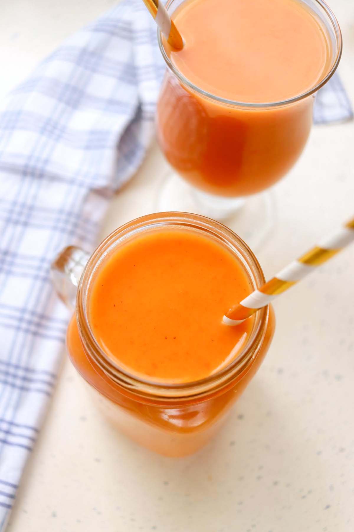 Pumpkin smoothie in a glass jar with a straw.