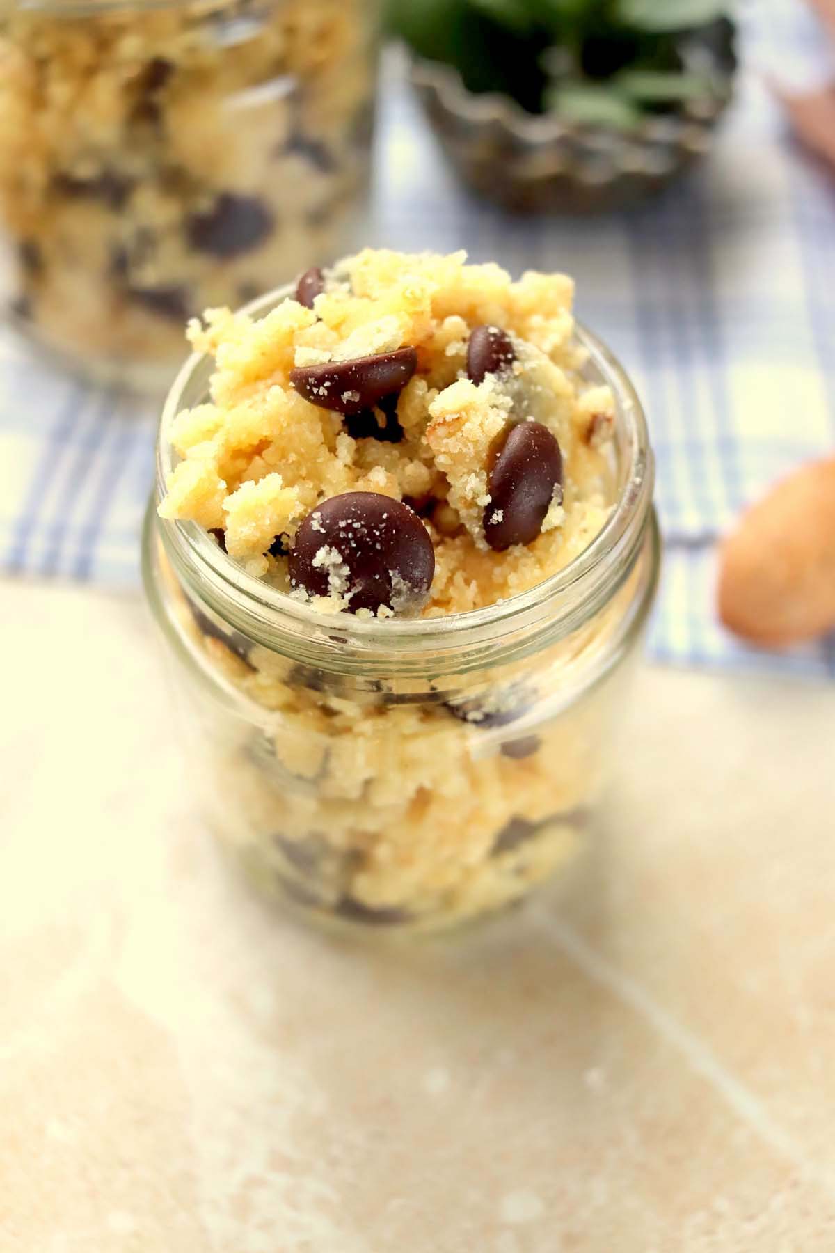 Cookie dough in a jar set on a wood table.