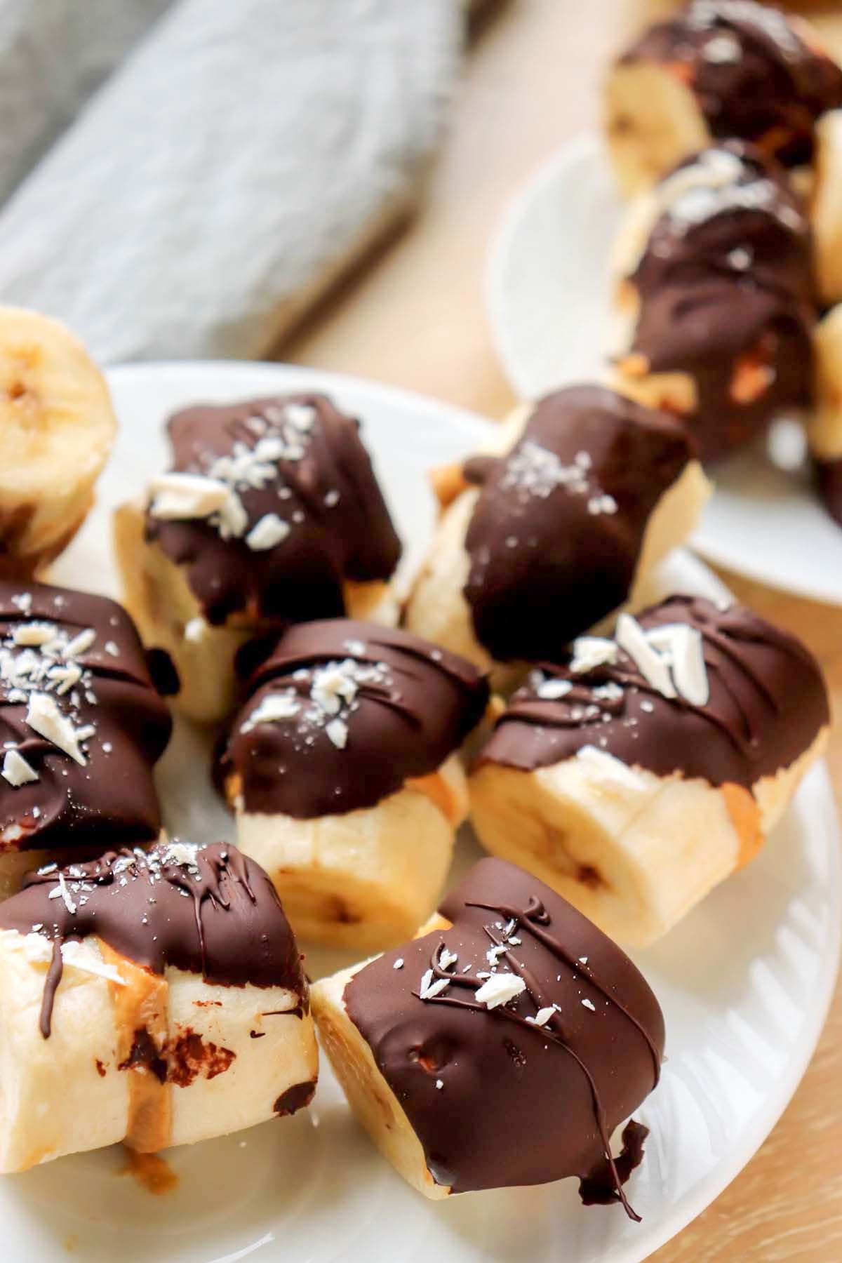 Banana bites on a plate set on a wood table.