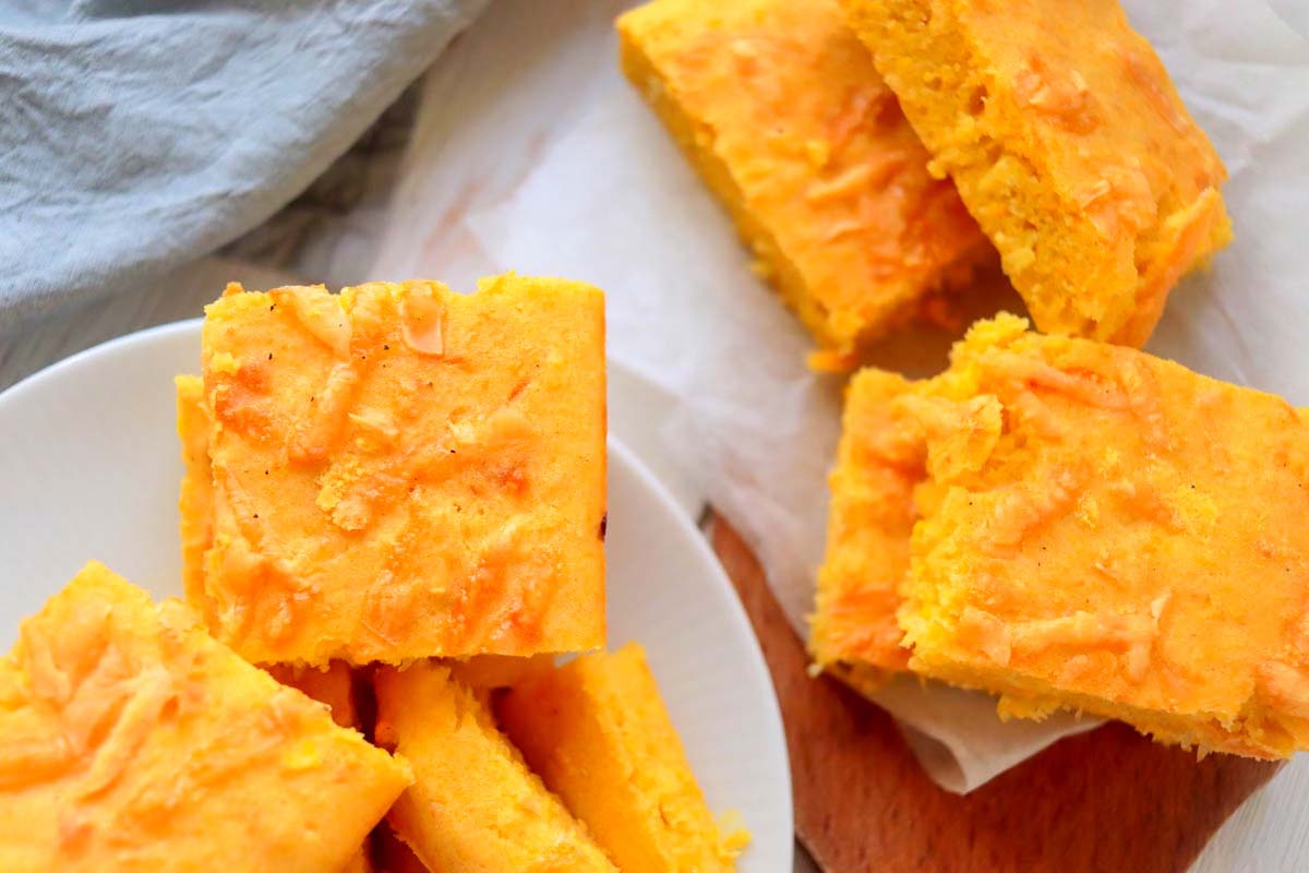 Sliced corn bread on a plate and a wood platter.