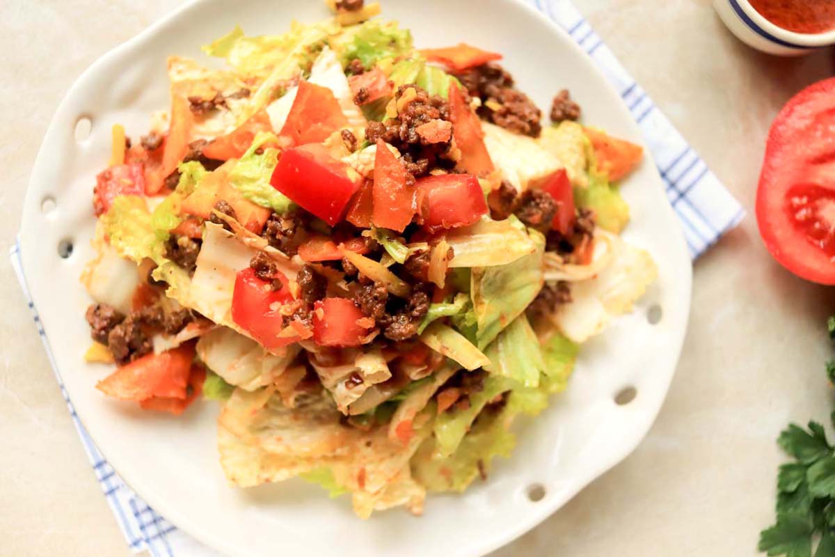 Taco salad on a plate set on a kitchen towel.