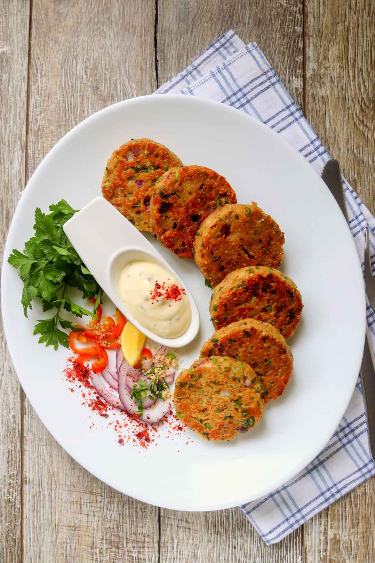 Patties on a plate garnished with vegetables.