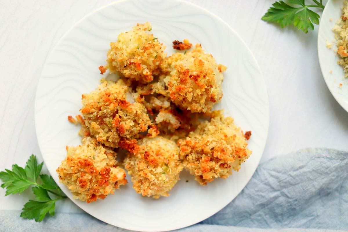 Cooked scallops on a white plate.