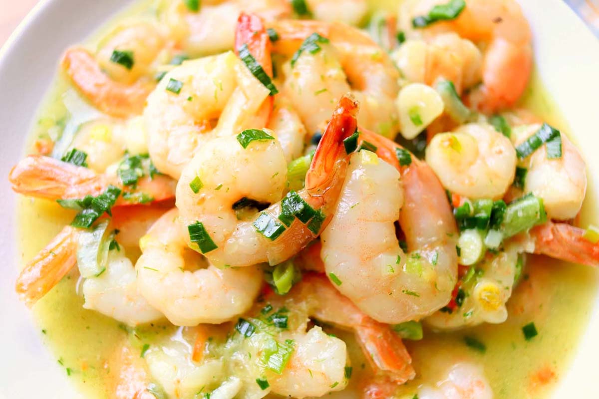 Shrimp scampi topped with green herbs.