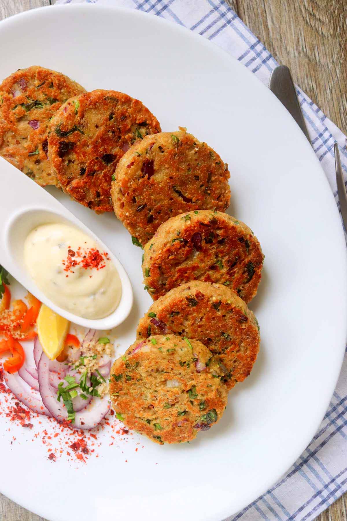 Tuna patties on a plate with a white sauce.