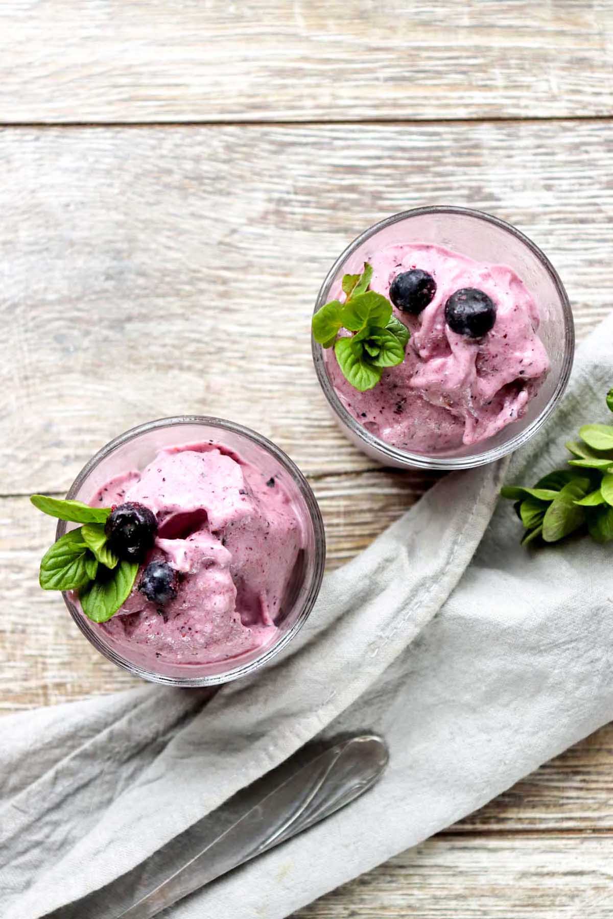 Two glasses of nice cream on a wood table.