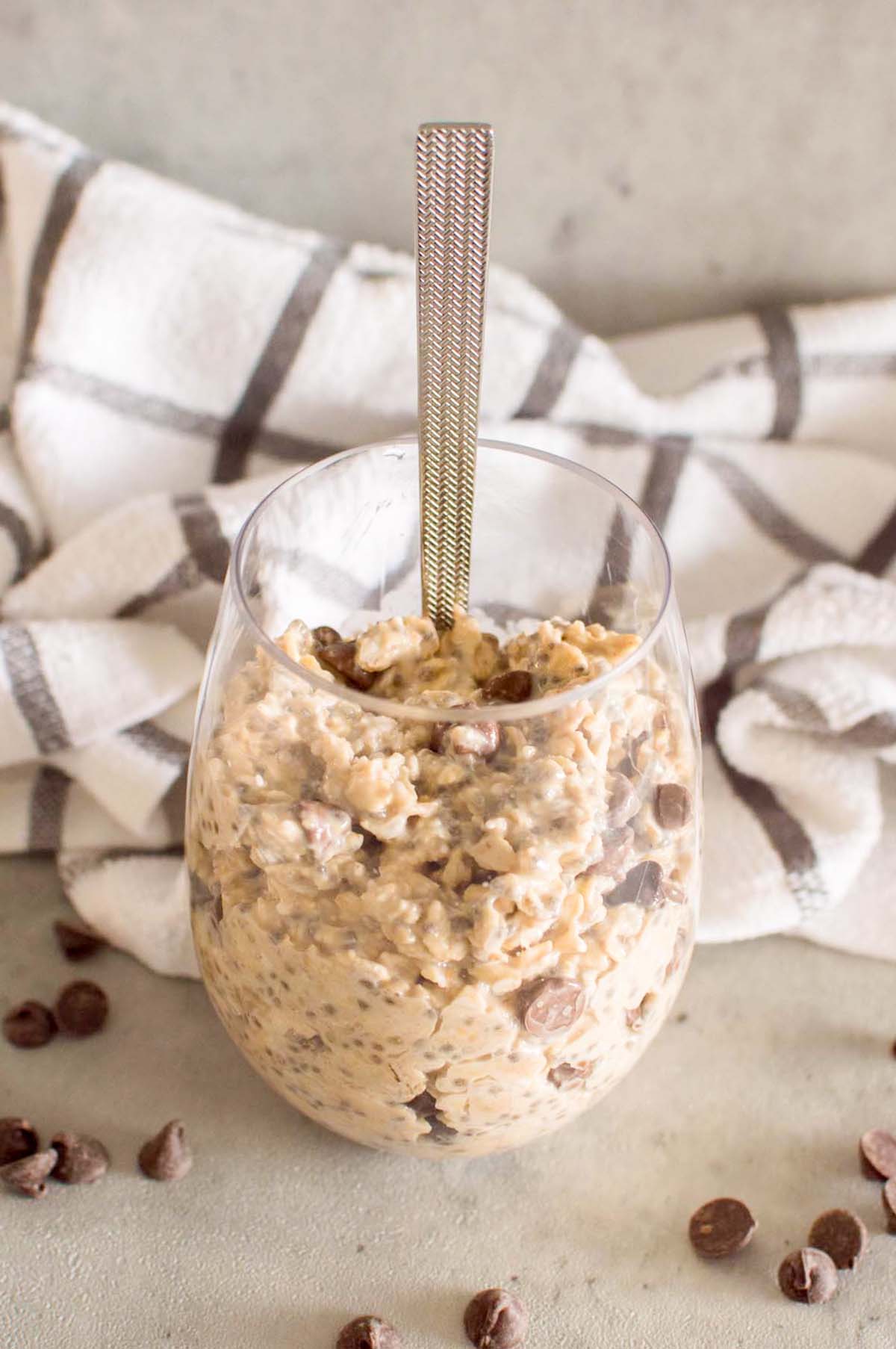 Oats in a glass with a spoon inside.