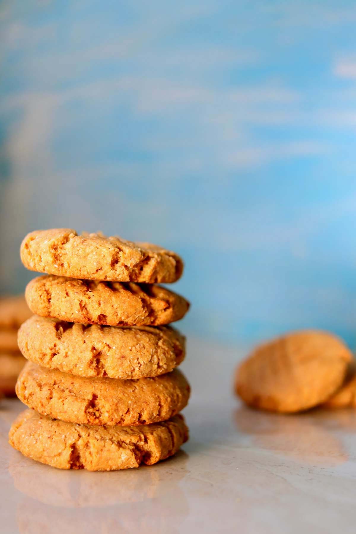 Stacked peanut butter cookies on a table.