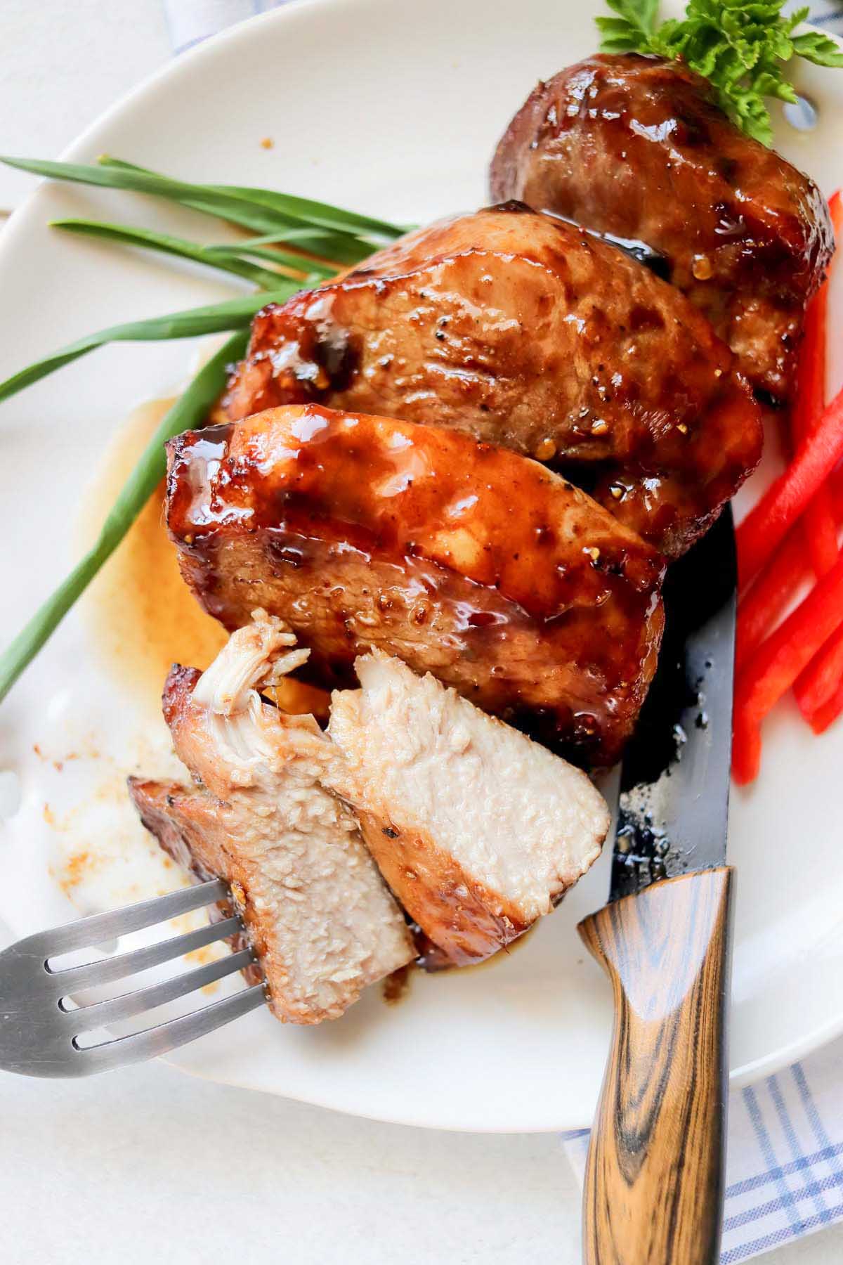 pork chop on a plate cut in half.