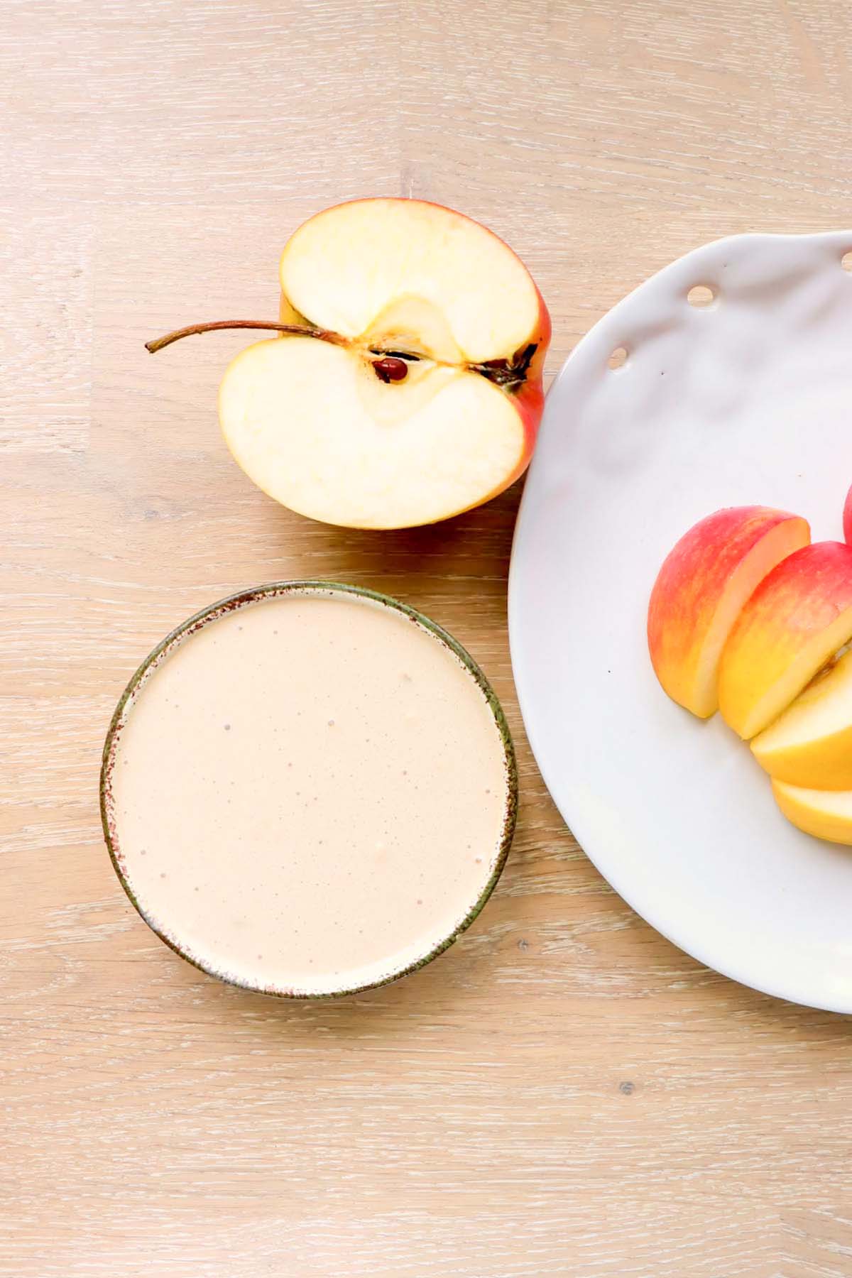 Dip in a bowl with half an apple next to it.