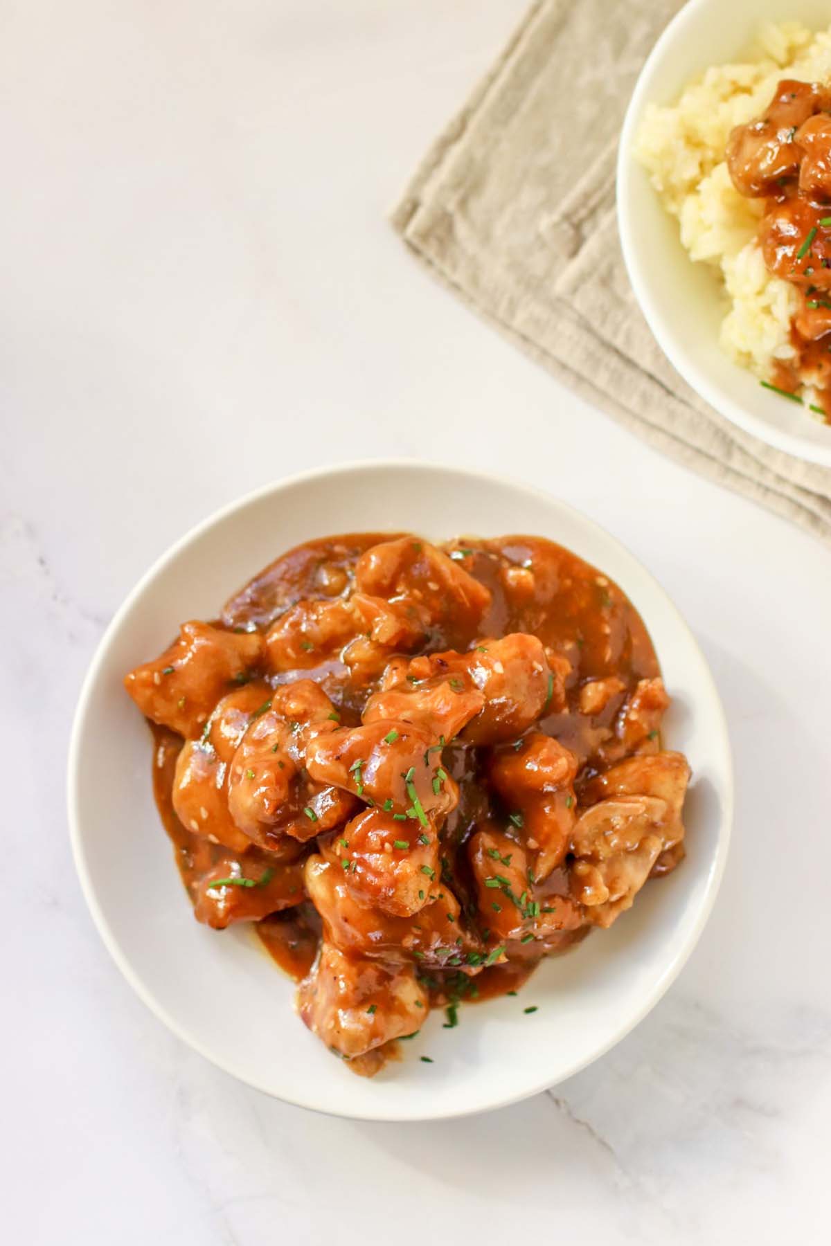 Sesame chicken in a white bowl.