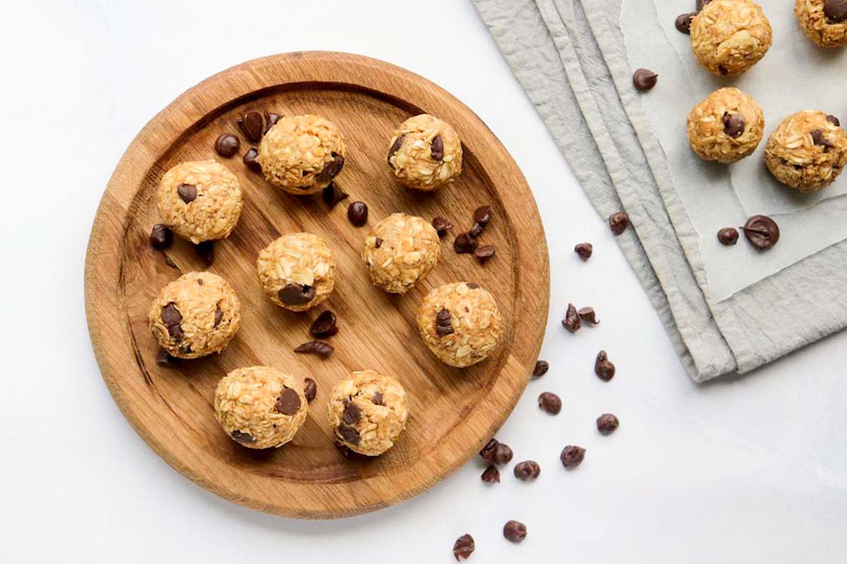Energy balls on a cutting board sprinkled with chocolate chips.