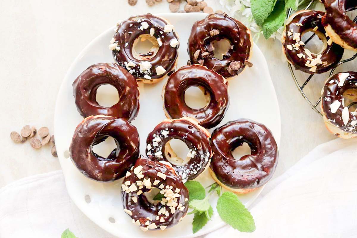 Donuts topped with chocolate frosting and nuts.