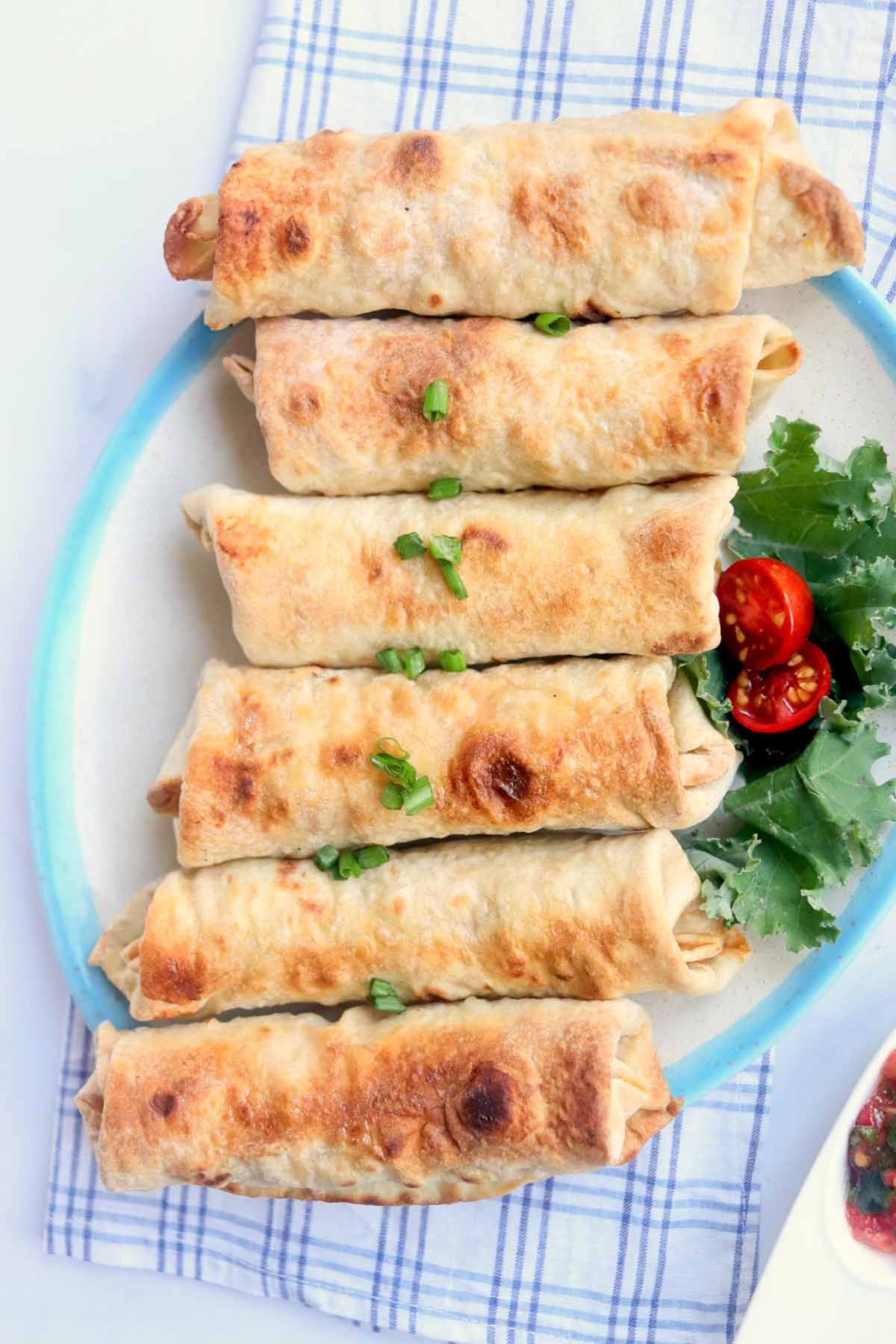 Chimichangas on a plate garnished with lettuce and tomato.