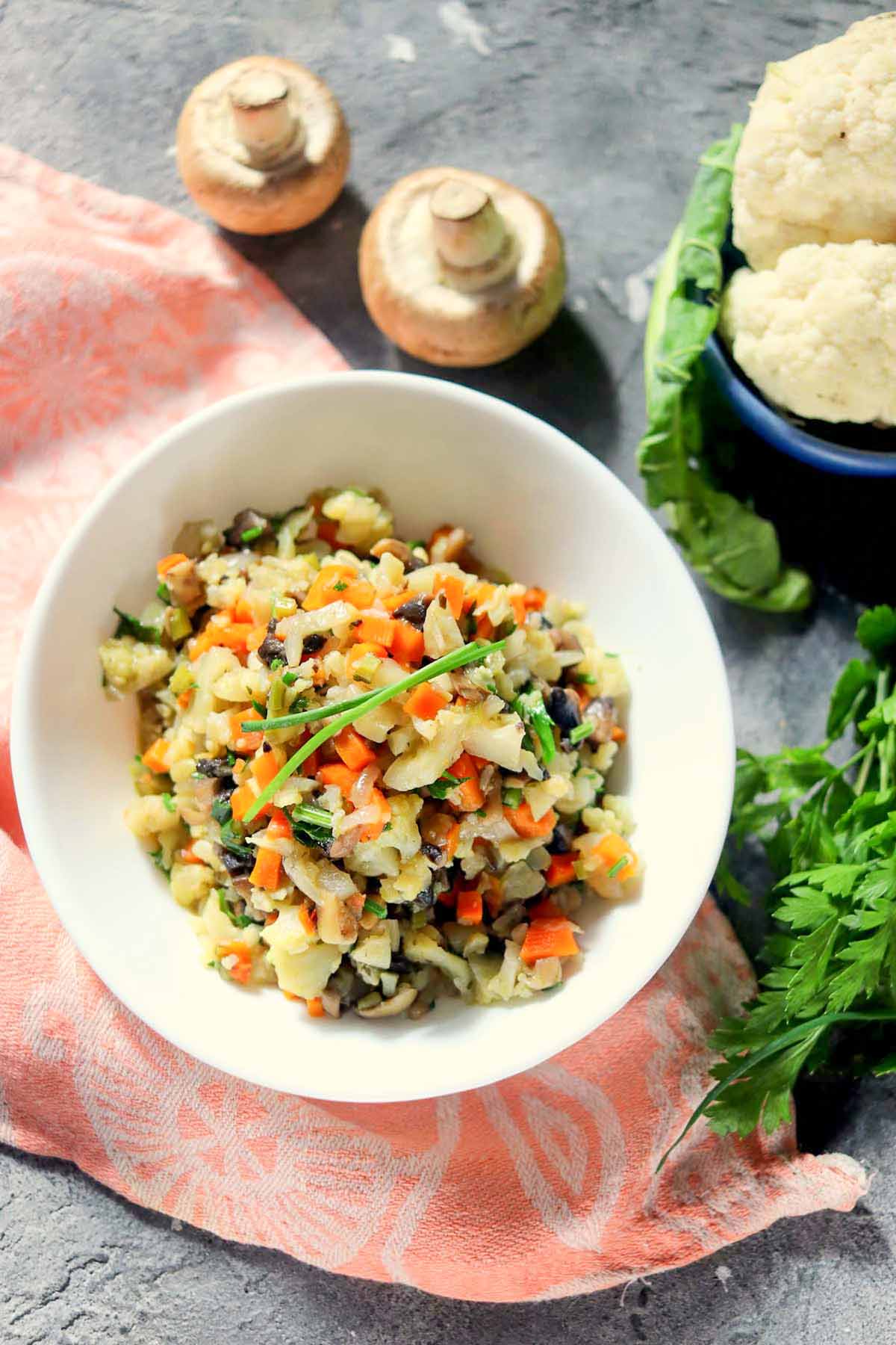 Stuffing in a white bowl set on a kitchen towel.