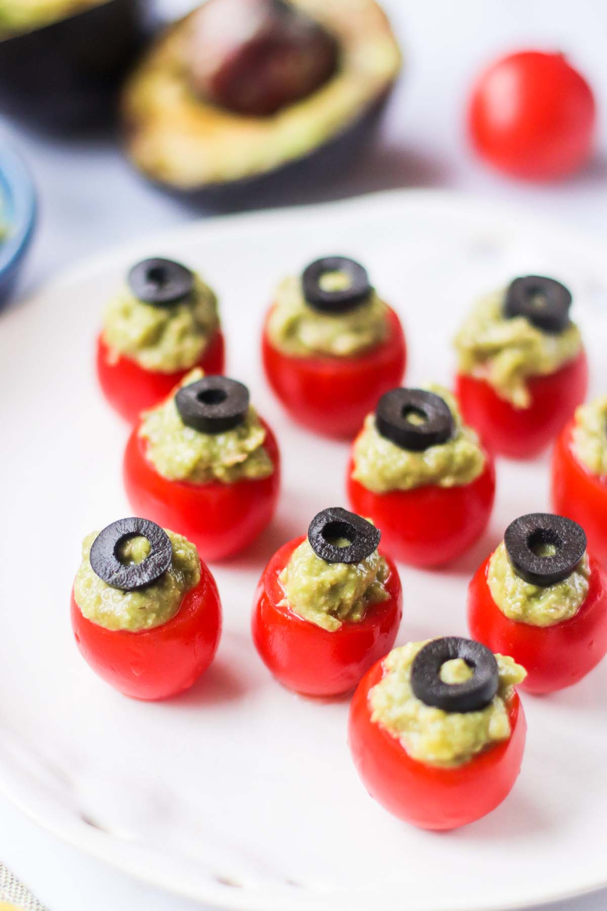 guacamole stuffed tomatoes topped with sliced olives.