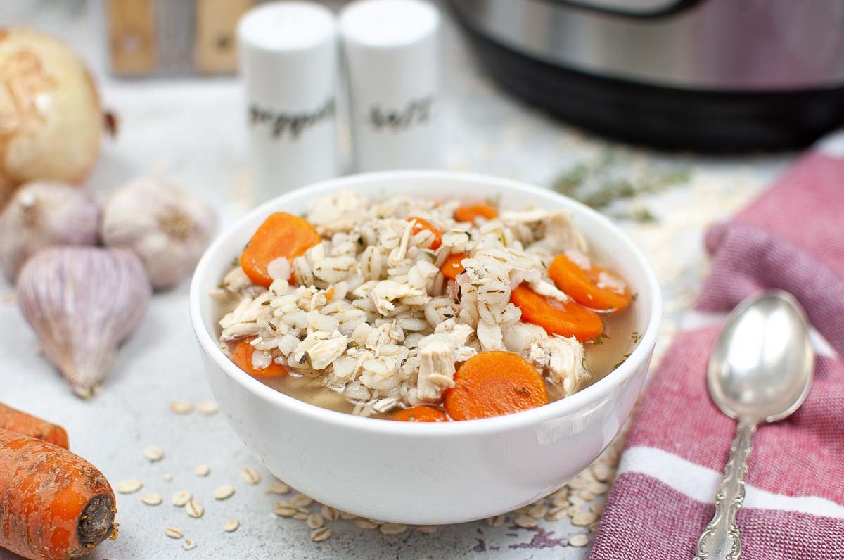 Soup in a bowl next to a spoon and towel.