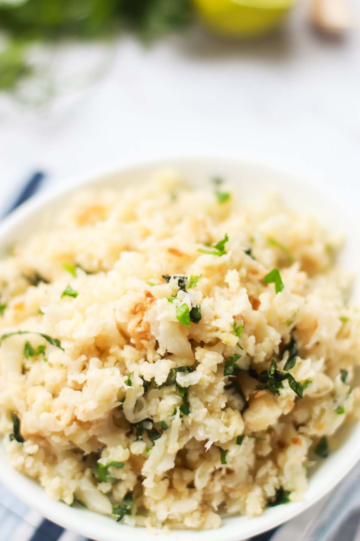 Cauliflower lime rice in a white bowl.