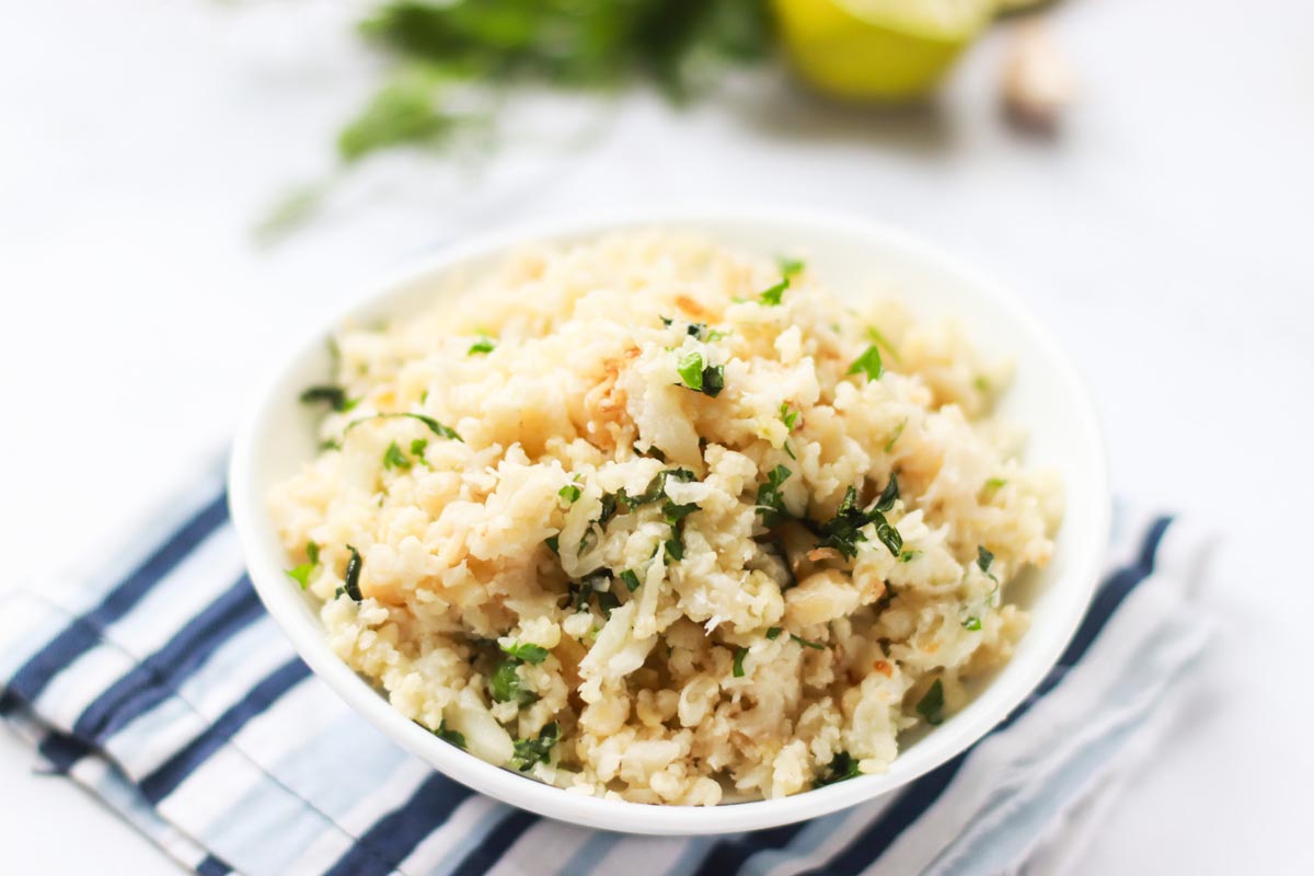 Rice in a bowl set on a kitchen towel.