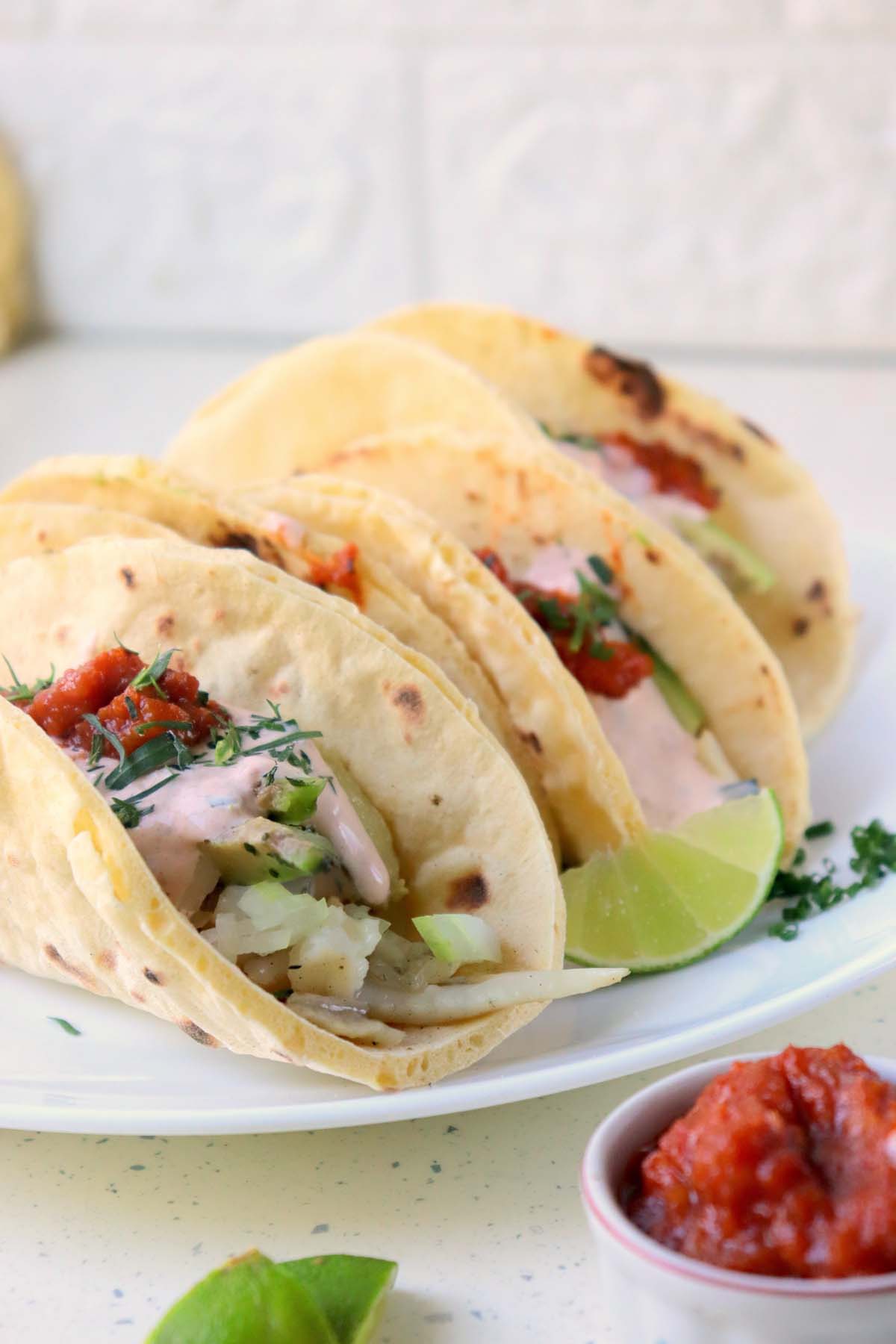 Tacos on a white plate.