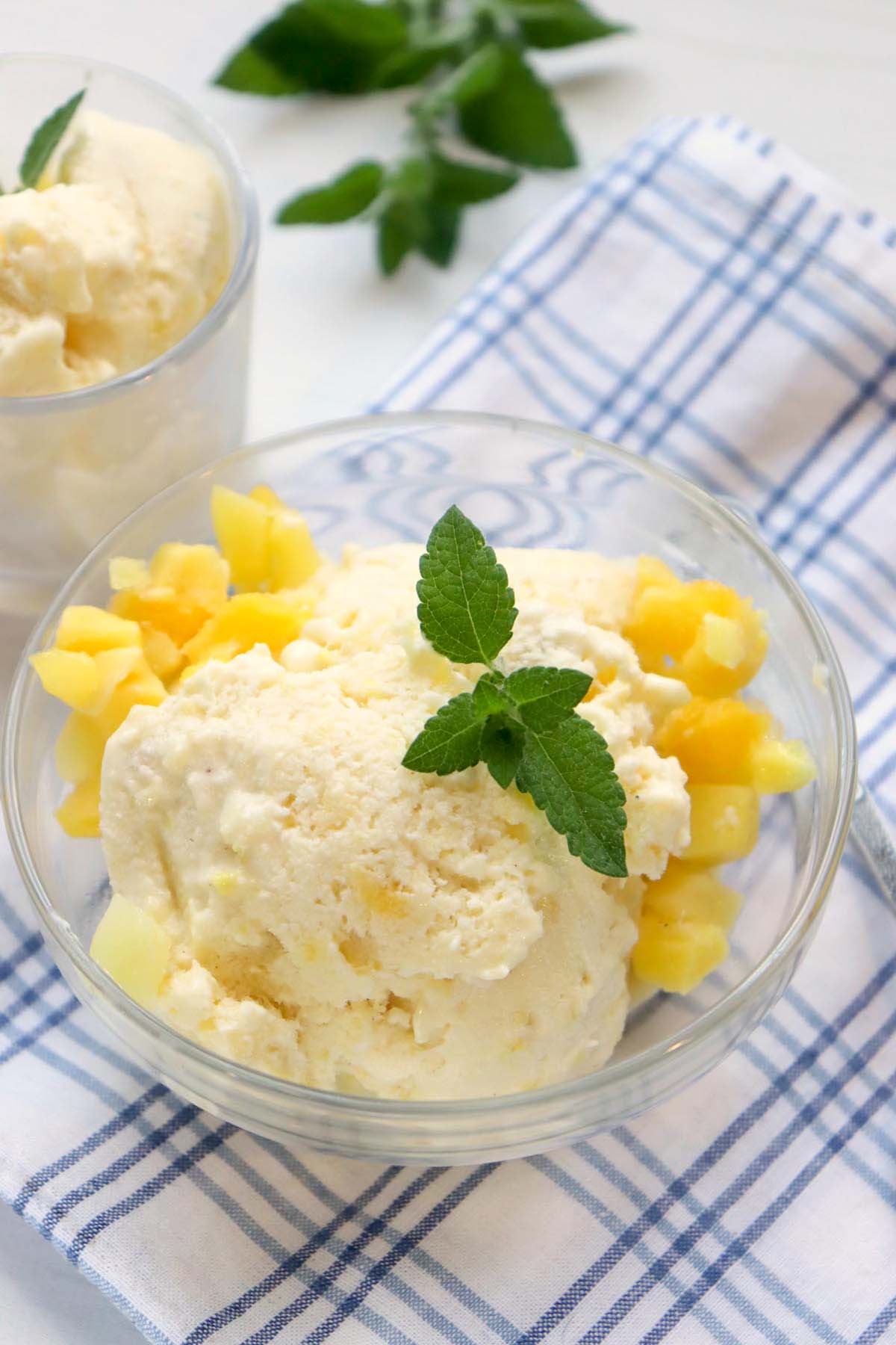 Nice cream in a bowl topped with chopped mango.