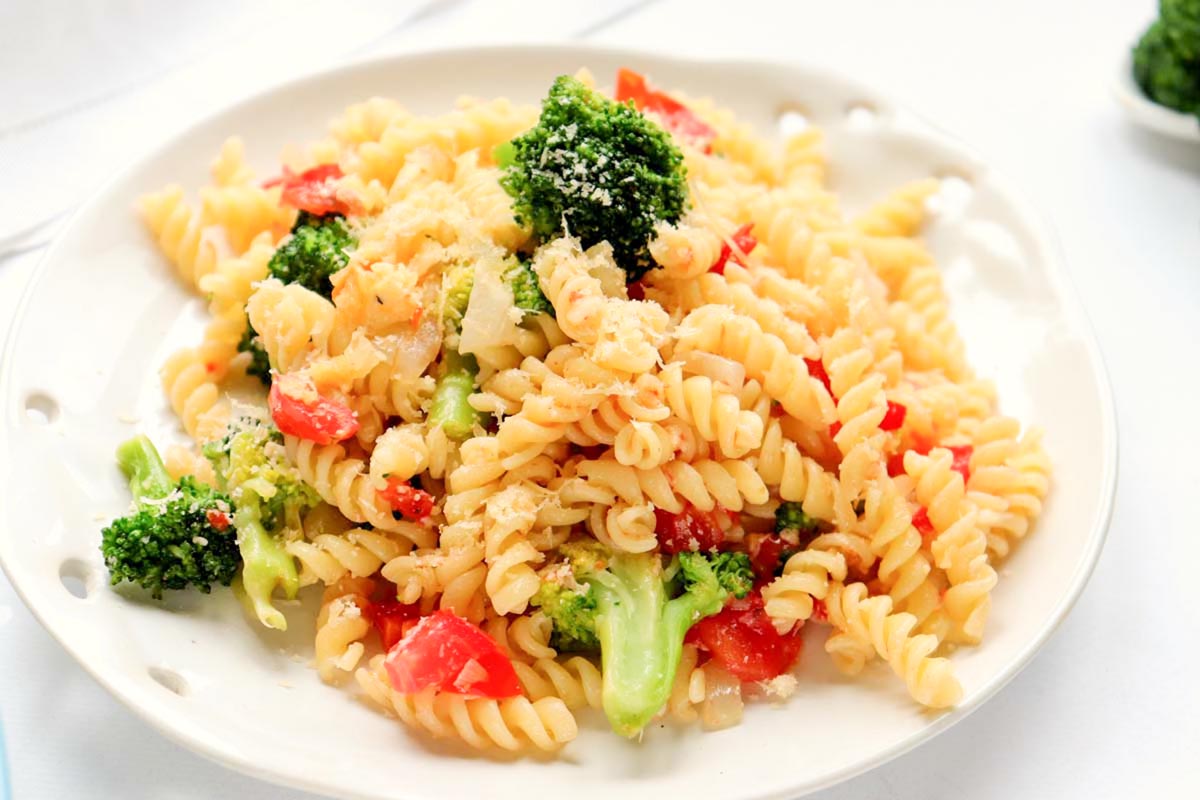 Pasta salad topped with shredded cheese.
