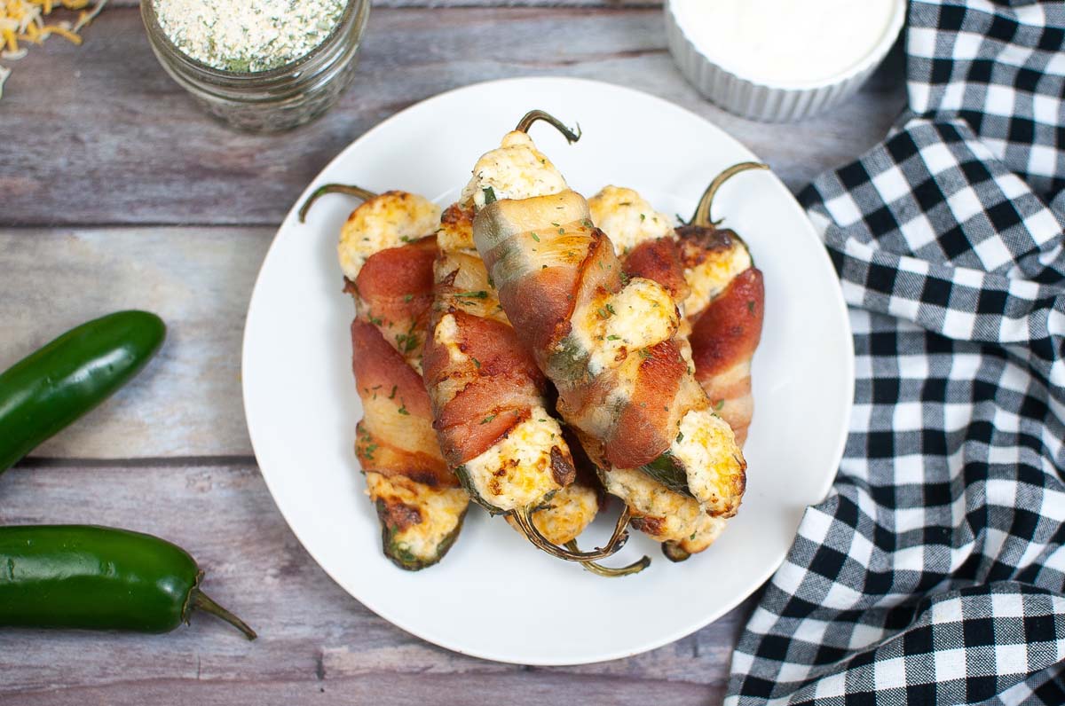 Poppers on a plate set on a wood table.