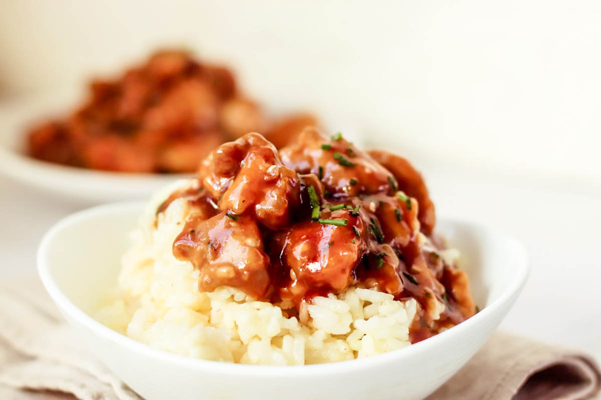 Chicken and rice in a white bowl.