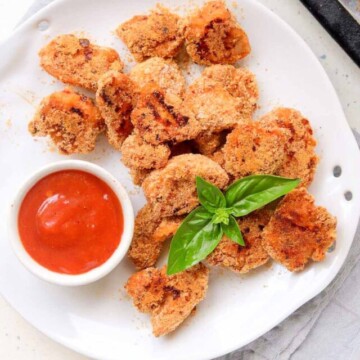 top view of chicken bites on a plate with dipping sauce.