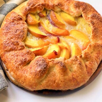 baked peach galette on a cutting board.