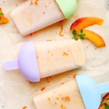 four peach popsicles on parchment paper.