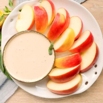 yogurt dip and sliced apples on a plate.