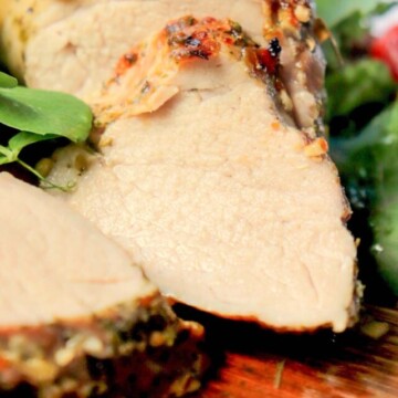 sliced pork tenderloin on a cutting board.