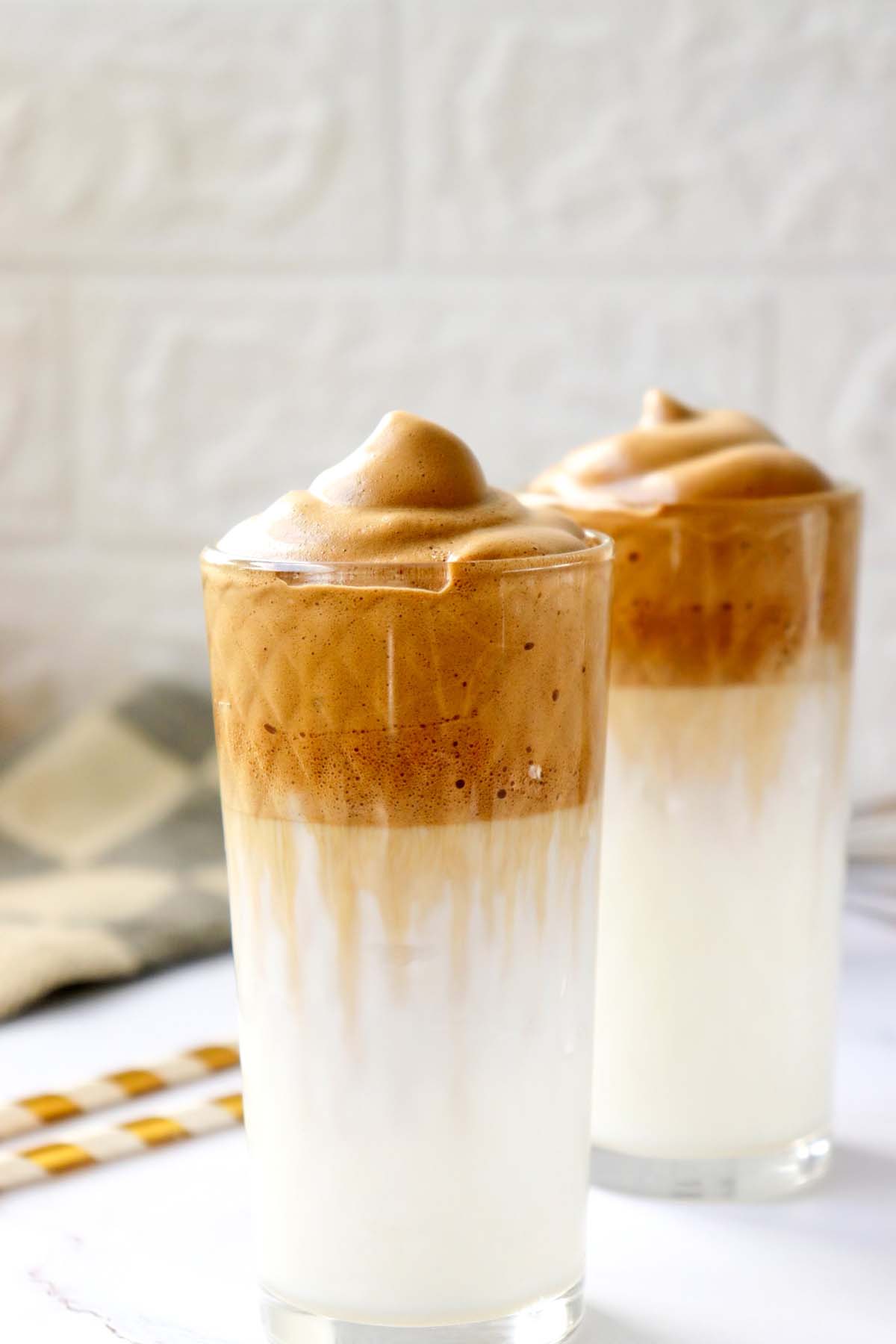Two glasses of milk topped with whipped coffee.