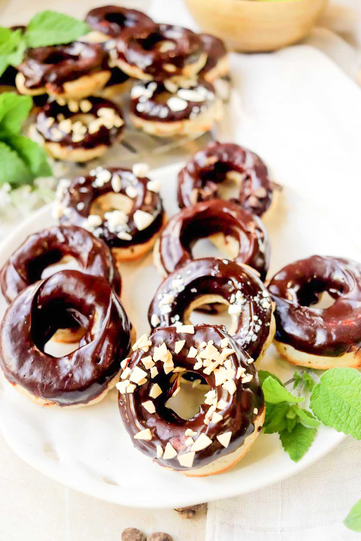 Chocolate frosted donuts on a white plate.