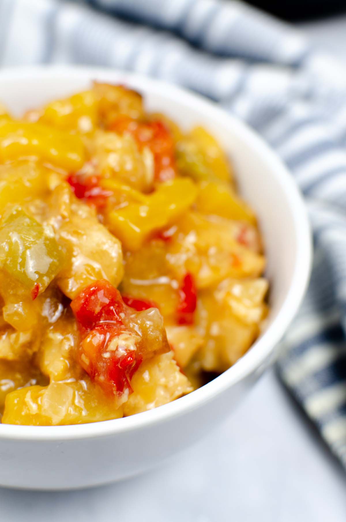 close up view of sweet and sour chicken in a bowl.