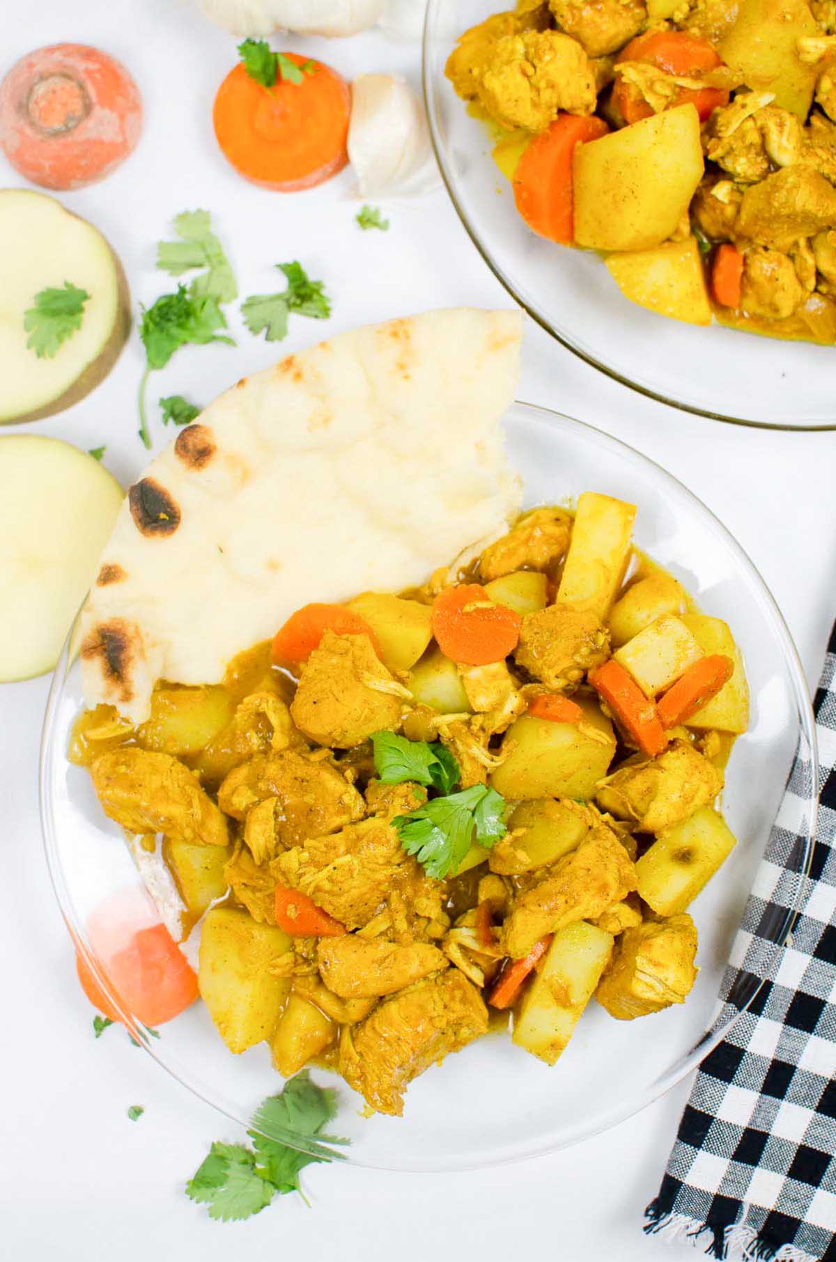 Chicken curry with a slice of pita bread.